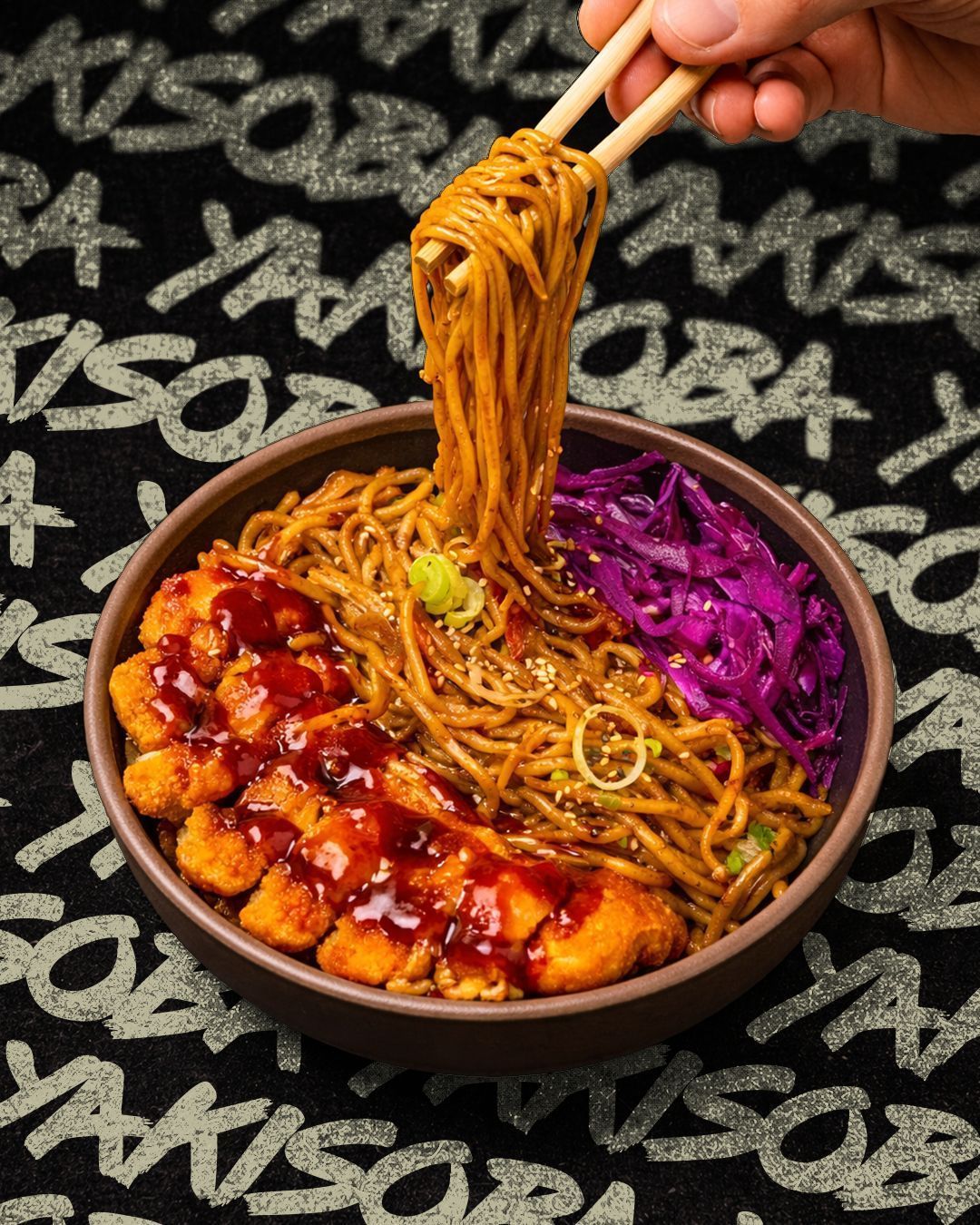 Bowl of restaurant nouilles with noodles, fried chicken topped with sauce, and purple cabbage at Nobi Nobi Bordeaux Victoire.