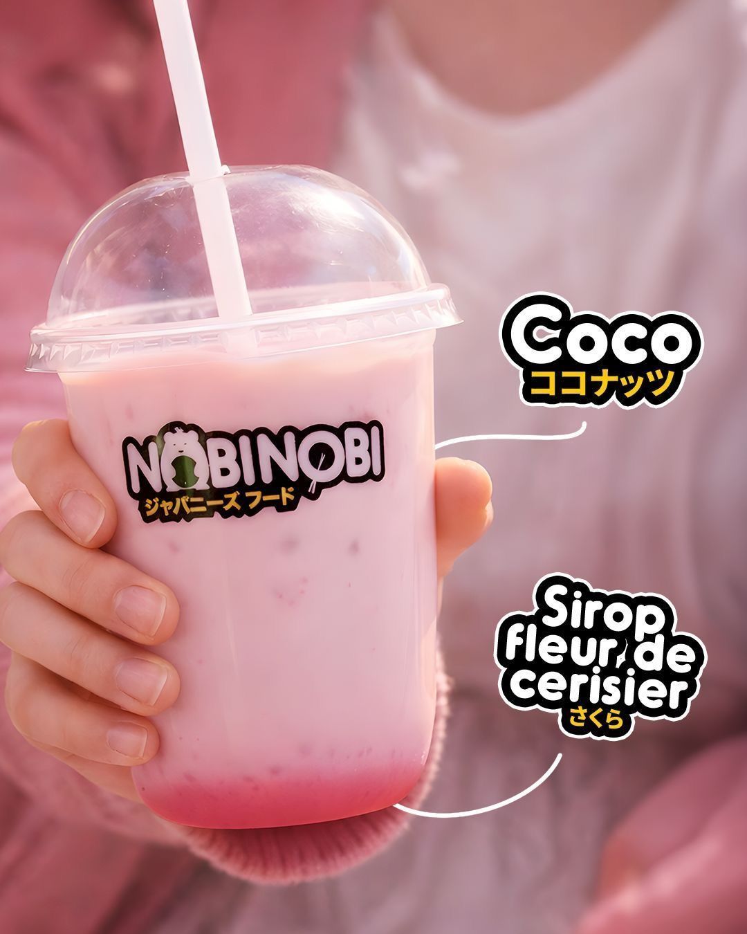 Té de burbujas coco con jarabe de flor de cerezo servido en vaso del restaurante Nobi Nobi. Bebida rosa con hielo y tapa.